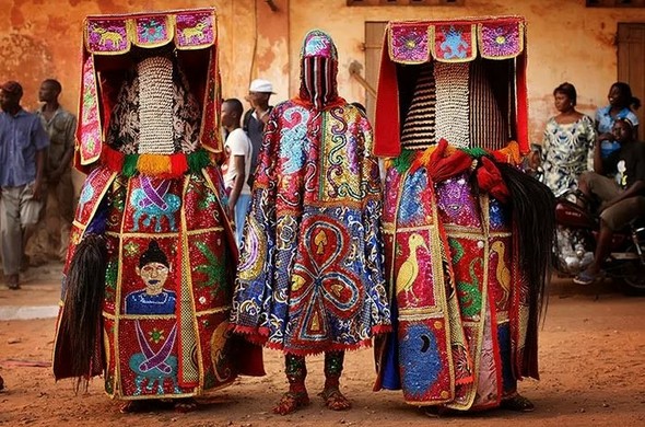 3 colorful egungun masked spirits in Benin, standing in front of the camera (not dancing as they usually do).
Each heavy costume has a lot of embroidery, with various symbols, animals...
The dancers are fully masked, and only the people attending the same Vaudoun temple know who they are.