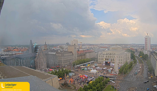 Webcam Augustusplatz. Er zijn activiteiten op het plein en donkere wolken in aantocht.