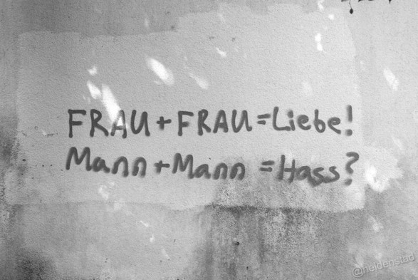Op een muur is een tekst gespoten:

Frau + Frau = Liebe!
Mann + Mann = Hass?