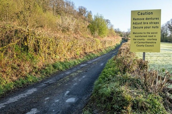 Sign on a country road somewhere in Wales (UK)

Caution
Remove dentures
Adjust bra straps
Secure your nuts

Welcome to the worst maintained road in the county - courtesy of Carmarthenshire County Council