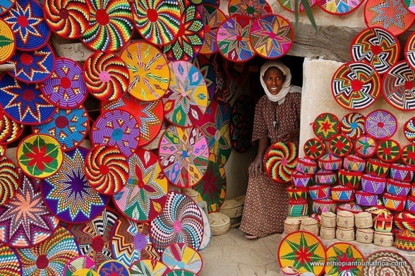 Photo of a shop or woven Ethiopian basketry, very colorful, with many designs made of spirals, stars...

