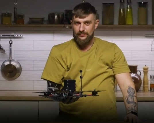 Ukrainian defender Mykola Voronchuk holding a drone with right hand prosthesis.