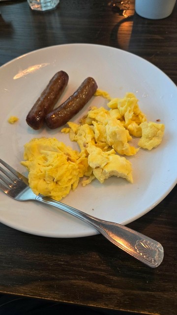 Sausage and scrambled eggs on a plate w/ a fork