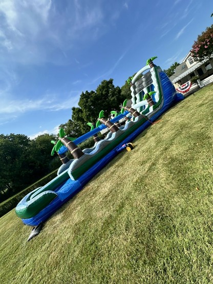 Description Provided in Tweet: 
Inflatable water course
---------------
Azure Generated Tags:
grass (99.86% confidence)
sky (99.59% confidence)
outdoor (99.59% confidence)
cloud (97.70% confidence)
tree (93.41% confidence)
playground (89.30% confidence)
vehicle (85.27% confidence)
blue (69.66% confidence)
field (66.67% confidence)

