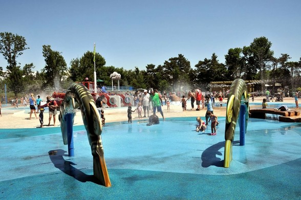 Azure Generated Description:
people at a water park (49.65% confidence)
---------------
Azure Generated Tags:
outdoor (99.05% confidence)
sky (98.35% confidence)
tree (94.24% confidence)
swimming pool (92.30% confidence)
playground (91.92% confidence)
water park (89.40% confidence)
leisure centre (88.35% confidence)
people (87.79% confidence)
ground (85.42% confidence)
water (82.11% confidence)
playing (81.78% confidence)
person (81.77% confidence)
group (78.40% confidence)
pool (73.17% confidence)
beach (70.71% confidence)
swimming (63.26% confidence)
standing (59.47% confidence)
