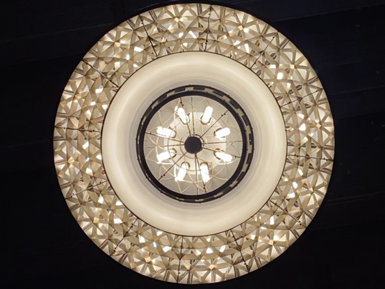 Gold and white circular chandelier viewed from directly below 