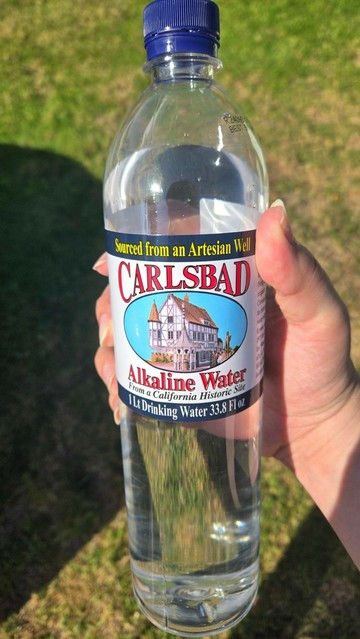 Me holding a bottle of Carlsbad Alkaline Water