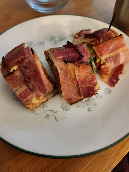 Three slices of a roll made with woven strips of bacon.