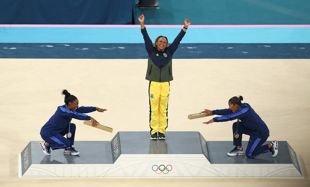 On the Olympic medals platform after women's gymnastics, the two Americans who silver and bronze smiled and bowed down to honor Brazil’s Rebeca Andrade, the gold medalist with her arms raised in joy.