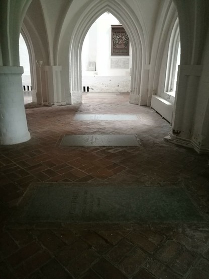 Photo of the crypt in Odense with tombstones inlaid in the floor.