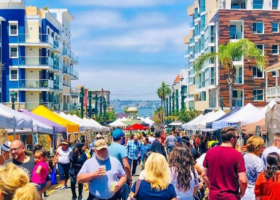 Picture of a crowded open farmer's market along a street.