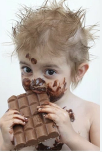 Random internet kid eating a chocolate bar as big as his head with chocolate smeared all over him.