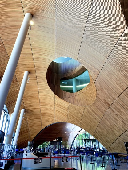 A inside of a big library building. The ceiling has a dome structure and covered by wooden plates. 