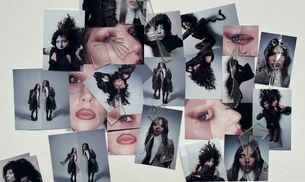 A spread of images of Lady Gaga overlaid with scattered broken glasses. Some images are cut outs laid on top of other images to show duality and distortion. Some images are really absurd close up of one eye and lips positioned together such that they look horrifying and weird. 