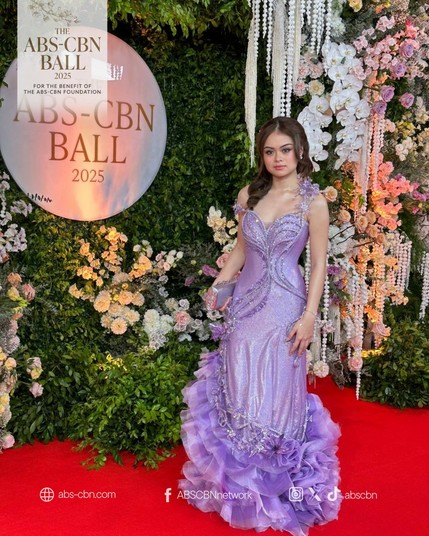 A celebrity arriving in a glittery and sparkly lilac gown.