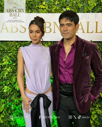 Julia Barretto in a lavender dress with her hips exposed and a black satin bow in the center of her waist area. Gerald Anderson sporting a burgundy velvet suit on top of a satin purple button-up shirt.