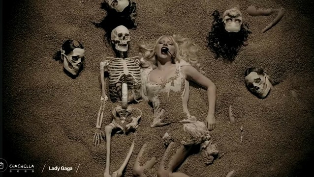 Lady Gaga buried in sand for her performance of Perfect Celebrity in Coachella 2025. She is surrounded by skeletons.