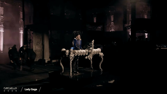 Lady Gaga playing on her piano. It is made of skulls and bones.
