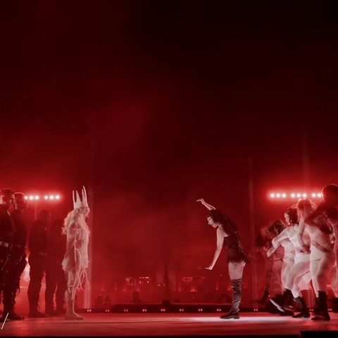 A battle between a lady in white (on the left) and her team in black against Lady Gaga as Mistress Mayhem (on the right) and her team in white.