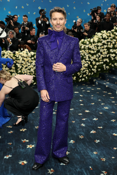 Raúl Domingo wwearing an all-purple ensemble of tux and trousers with a bow around his neck.