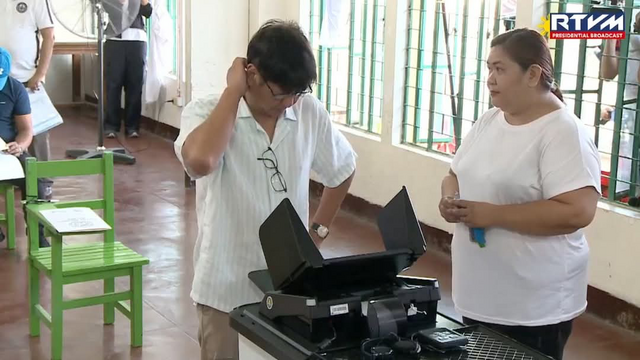 Philippine President Bongbong Marcos visibly frustrated at the automated vote counting machine having a glitch as he is submitting his votes for the 2025 National Elections. Beside him is a poll officer trying to keep her smile through the heat of the president seeing the fuck up first hand.