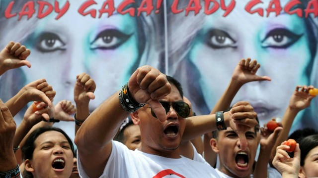Religious groups from the Philippines gesturing a thumbs down at Lady Gaga's Born This Way Ball Tour.