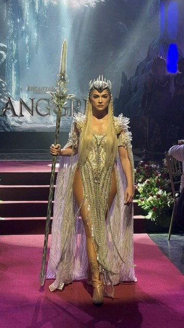 Rhian Ramos as Mitena for Encantadia Chronicles: Sang'gre. She wears a dazzling, crystal-embellished bodysuit with structured shoulder accents, a sheer flowing cape, and nude high heels. Her look is completed with a silver spiked crown and an ornate staff, emphasizing a regal, warrior-like presence.