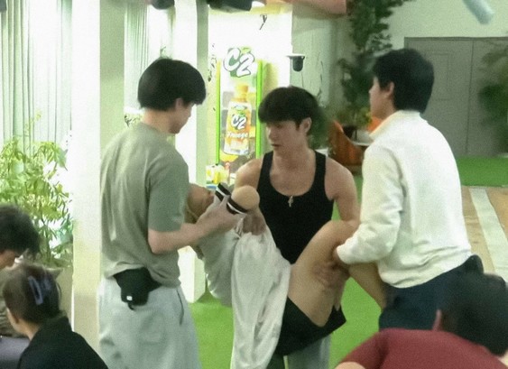 A shot from Pinoy Big Brother where one of the housemates, Klarisse, passed out from being too drunk. Three male housemates carry her back into the quarters.