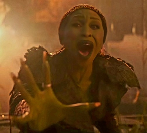 Cynthia Erivo as Elphaba in Wicked: For Good. She is screaming at the top of her lungs and reaching forward with her right hand.