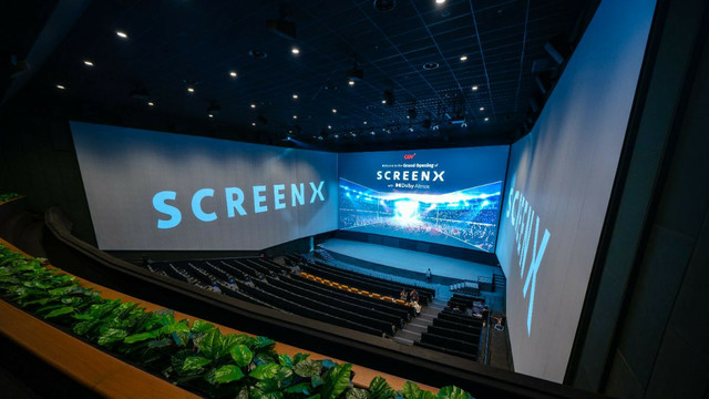 A theater with ScreenX panels. The main panel is at the center where a regular cinema panel would be, and the left and right walls are also screens. But these side screens have a more washed out color rendering. The seams where the three panels merge are also very visible.