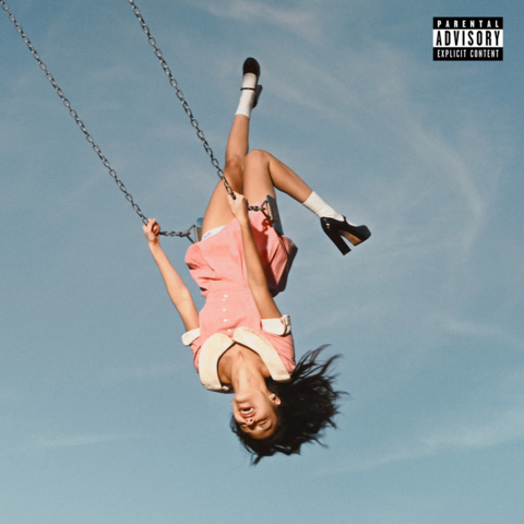 Album cover for Olivia Rodrigo's new album. She is riding a high swing lifted up so high she's upside down with a huge laugh plastered on her face. In the background is a bluish gray sky with light swirls of thin clouds. The tag "Parental Advisory: Explicit Content" can be seen on the top right corner.