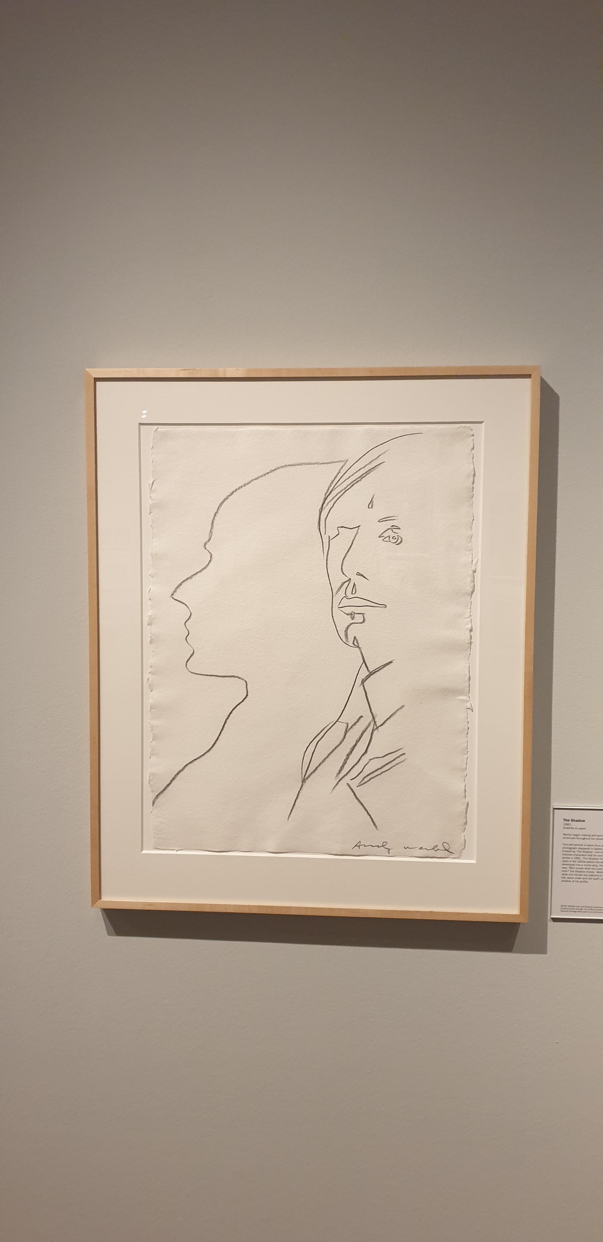 A framed graphite drawing on paper by Andy Warhol  ... part of the Tate Artist Rooms loan Warhol exhibition currently at Wolverhampton art gallery.
Drawn around 1980 Warhol here drew a self portrait.  To the left is an outline silhouette. To the right is his self portrait proper.